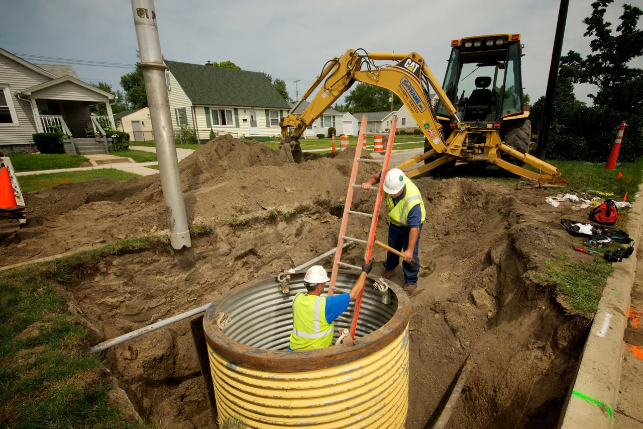 Bob Frame Plumbing crew members working in a street excavation