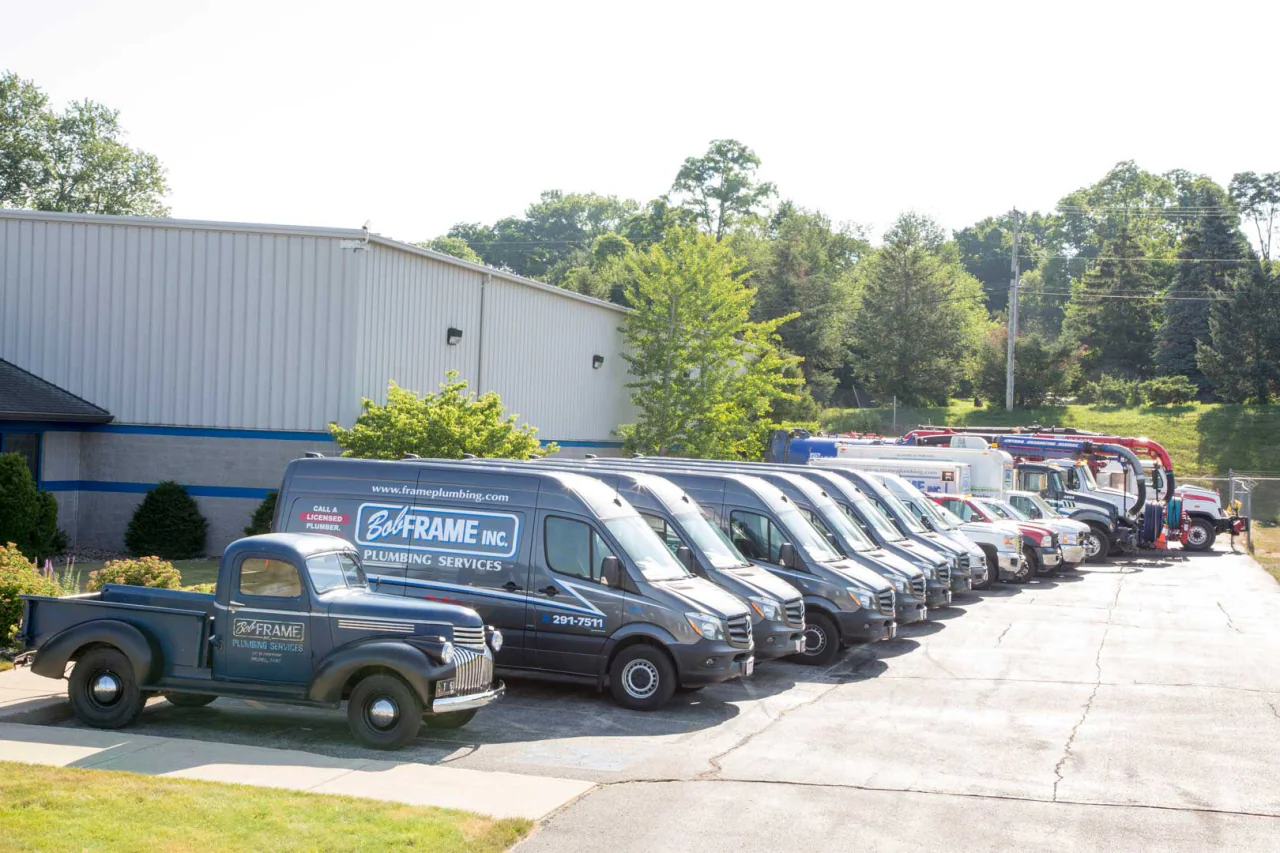 Bob Frame Plumbing service vans lined up with a vintage Frame truck