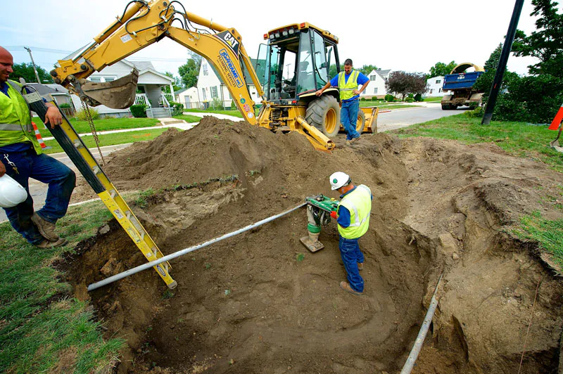 A Bob Frame Plumbing crew locating lines at a street excavation